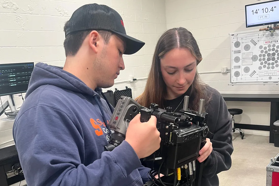 Two students look at a camera.