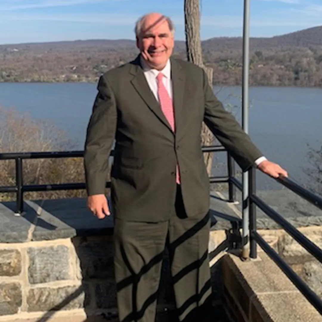 Vincent “Vinny” P. Longhi Jr. stands in front of a lake.