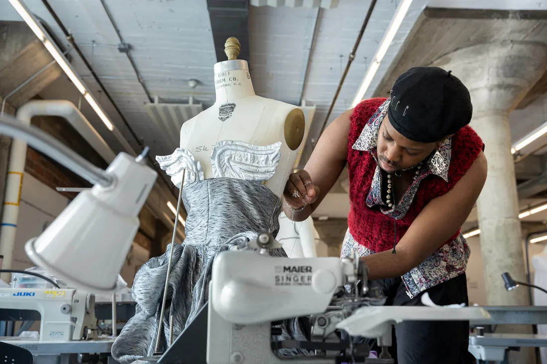 A student works on a garment on a mannequin.