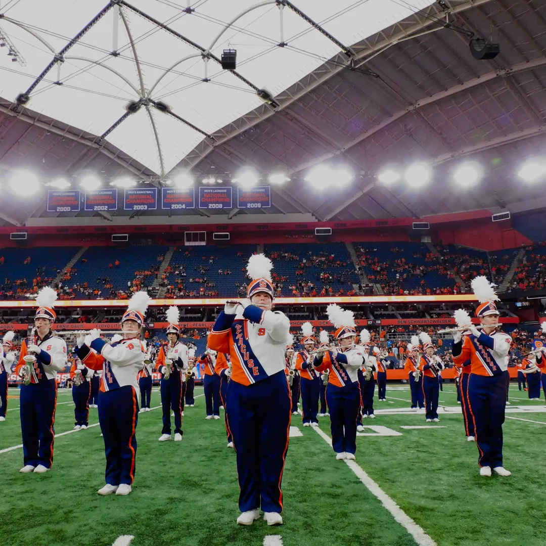 Individuals play instruments on the field in the Dome.