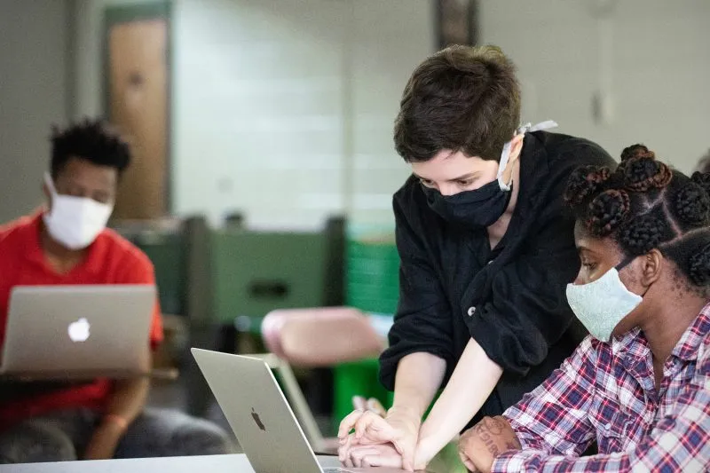 An individual leans over a computer.