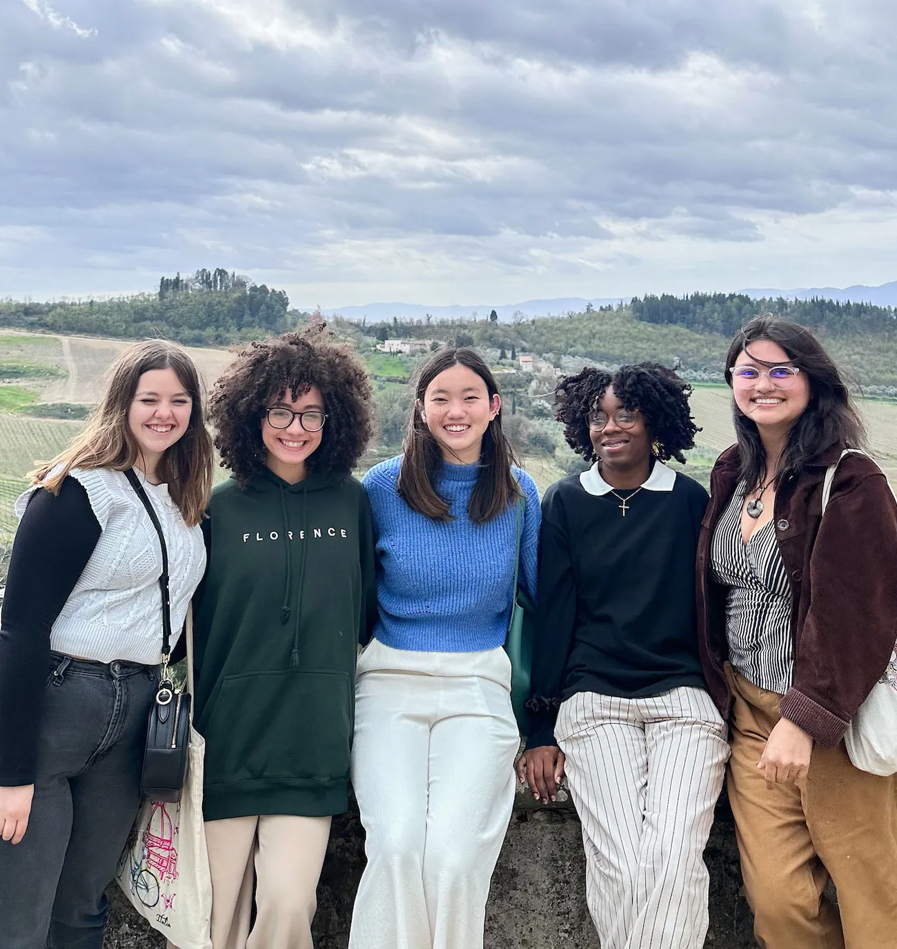 A group of students pose in front of a scenic overlook of Florence, Italy.