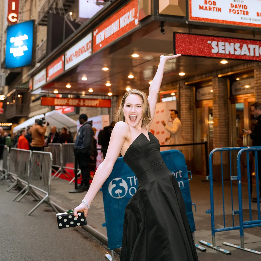 Tristen Buettel poses on Broadway in New York City in front of a marquee.