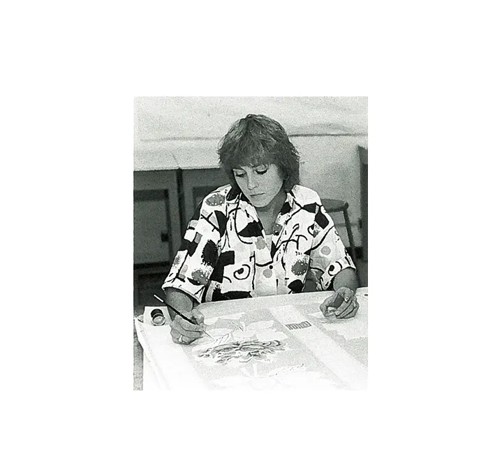 A woman draws on a piece of paper.