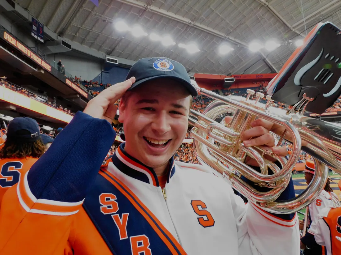 A person smiles while holding their instrument in the Dome.