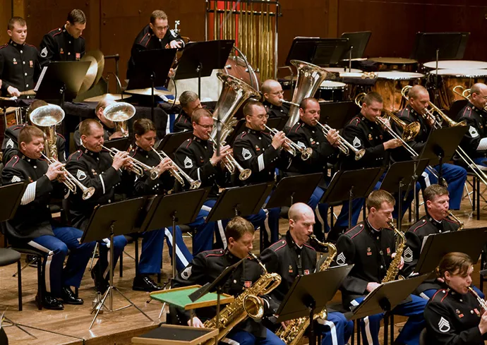 People in the West Point Band playing instruments on stage.