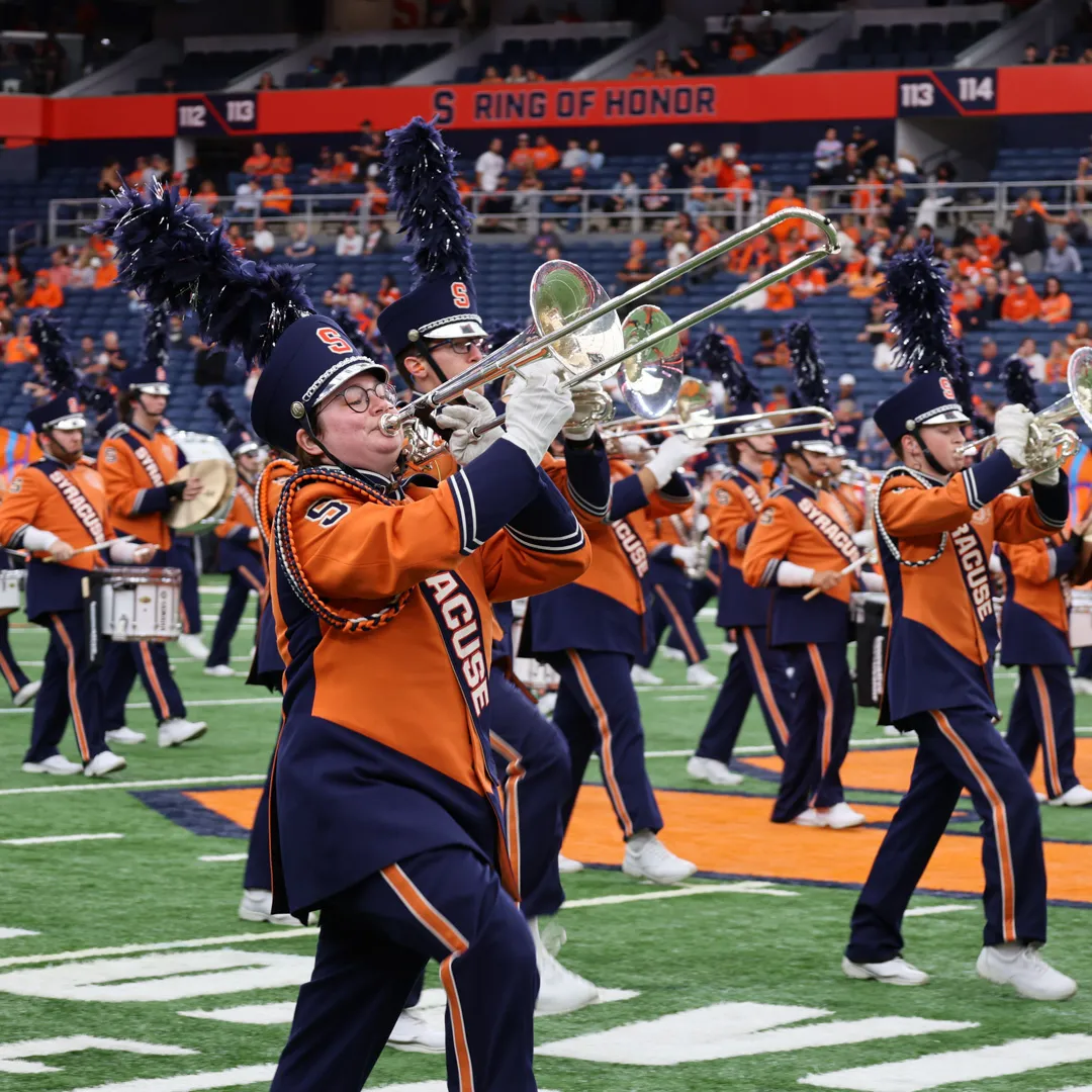 A trombone player marches across the field in the Dome.