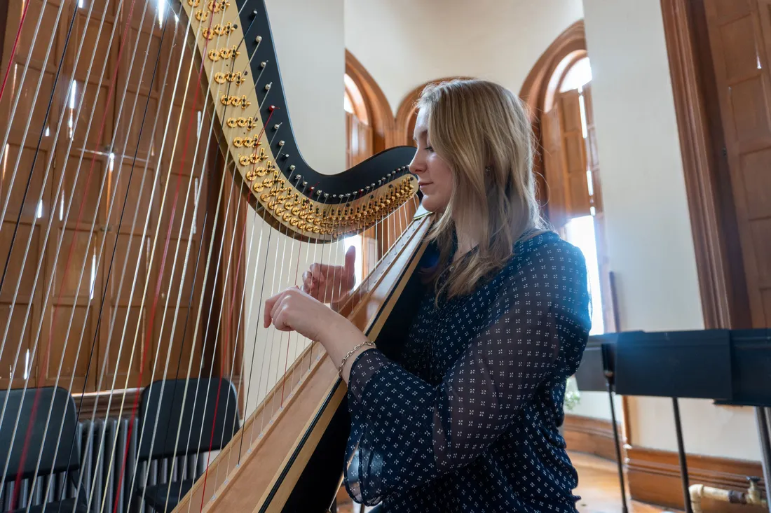 A person plays a harp.