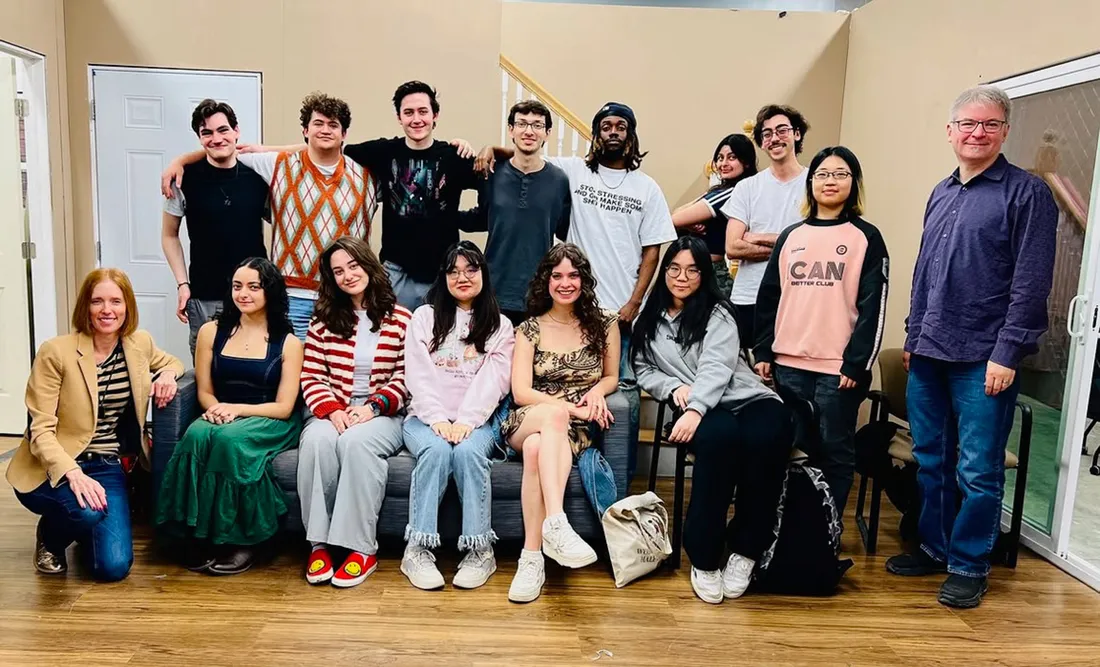 Students and two faculty members pose for a group photo.