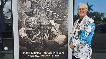 Tyler Smith standing next to a poster of artwork.