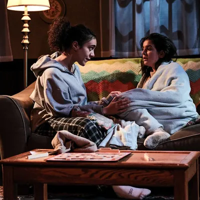 Two individuals sit on a couch.