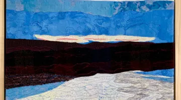 A fiber/fabric landscape of blue, black and white.