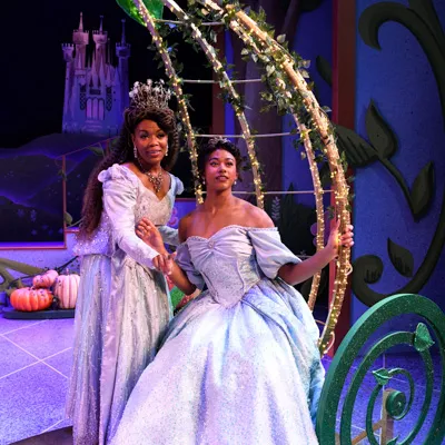 Two people dressed in gowns standing on a stage.