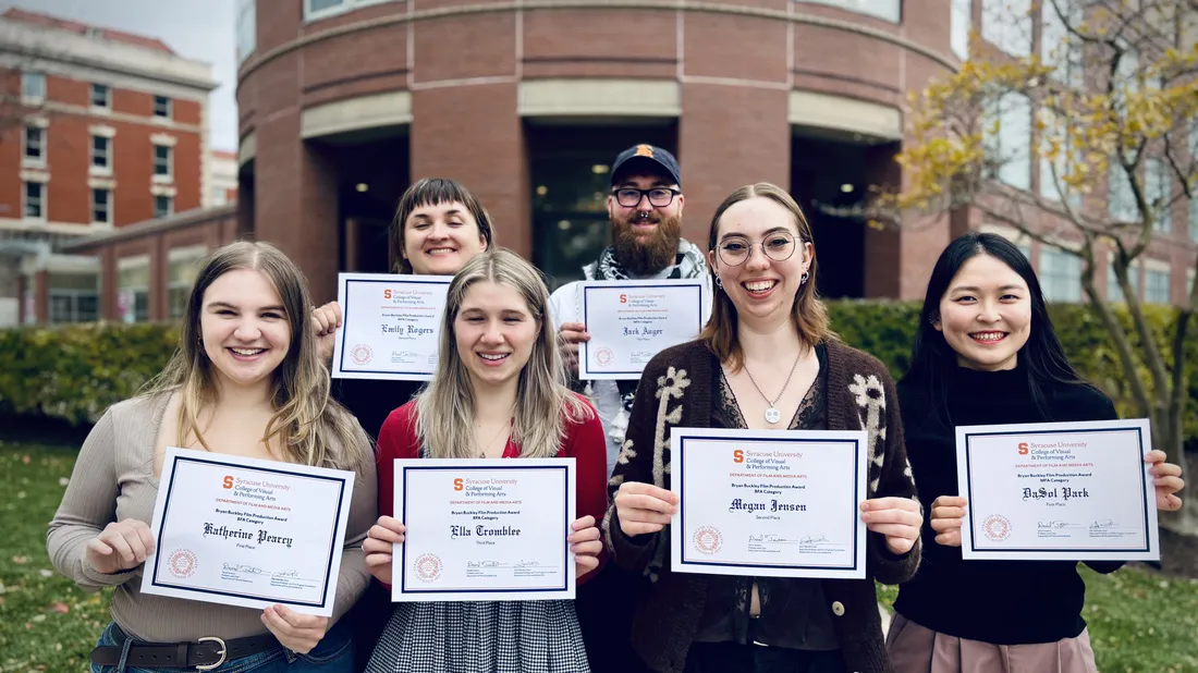 Six people hold certificates outside of Shaffer Art Building.