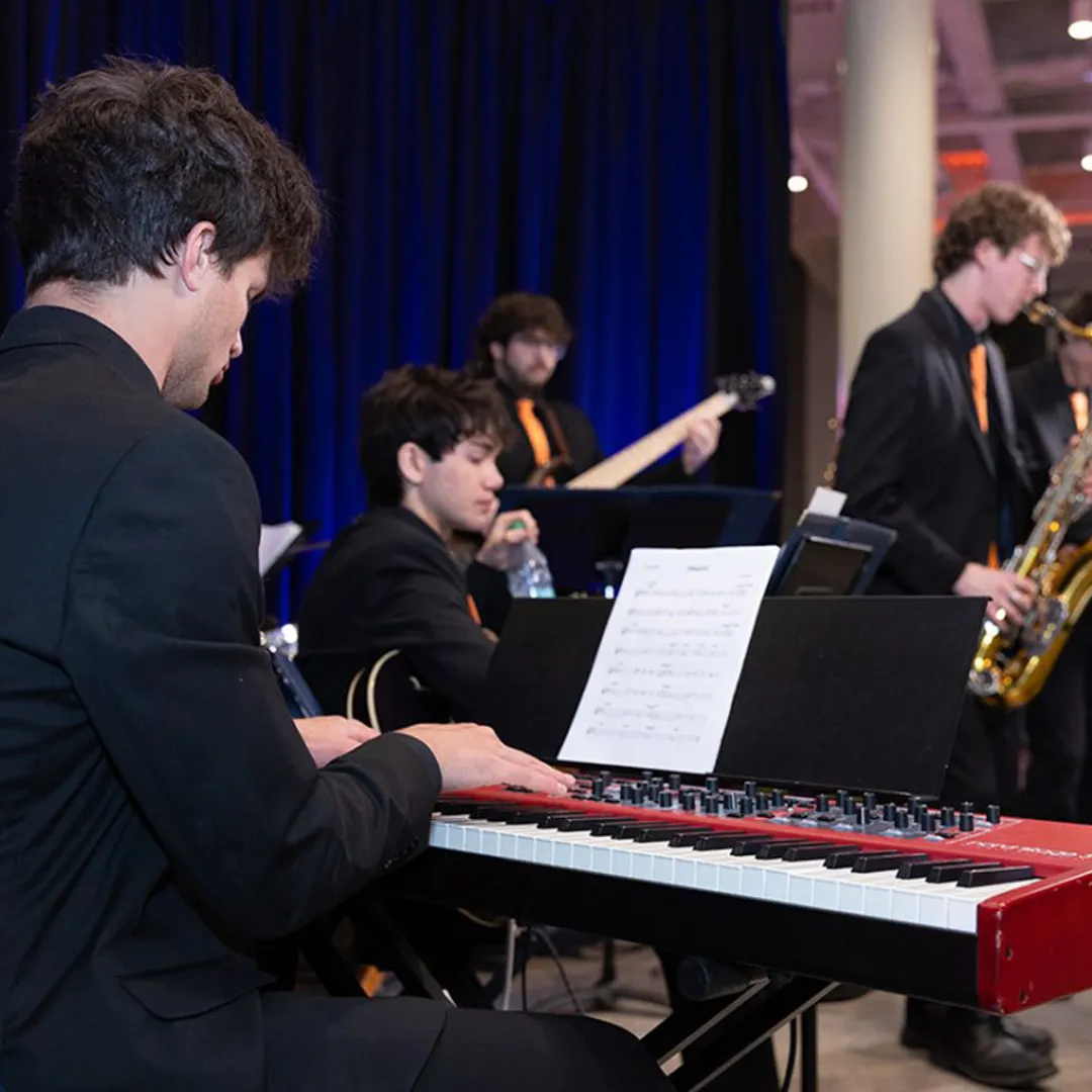 A person plays the piano on stage.