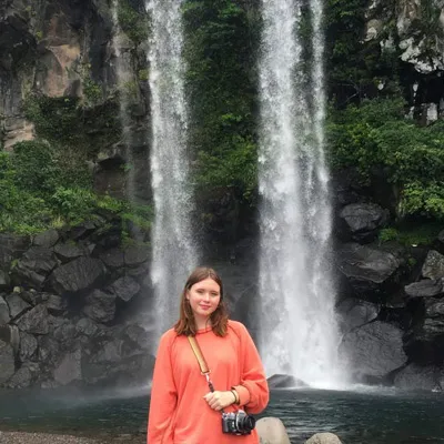 Charlotte Howard in front of a waterfall.