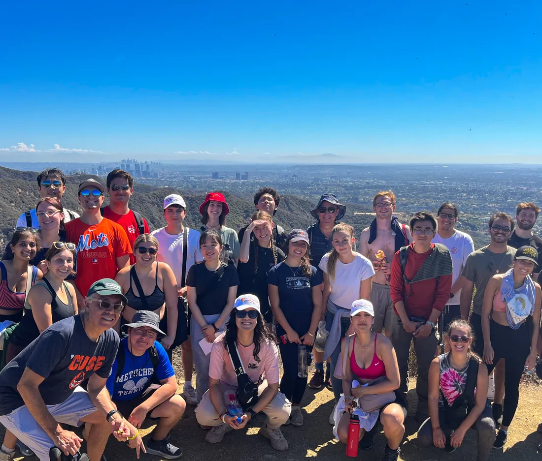 A group of students pose at a scenic overlook of Los Angeles.