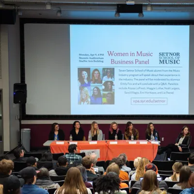 Individuals listen to a panel.