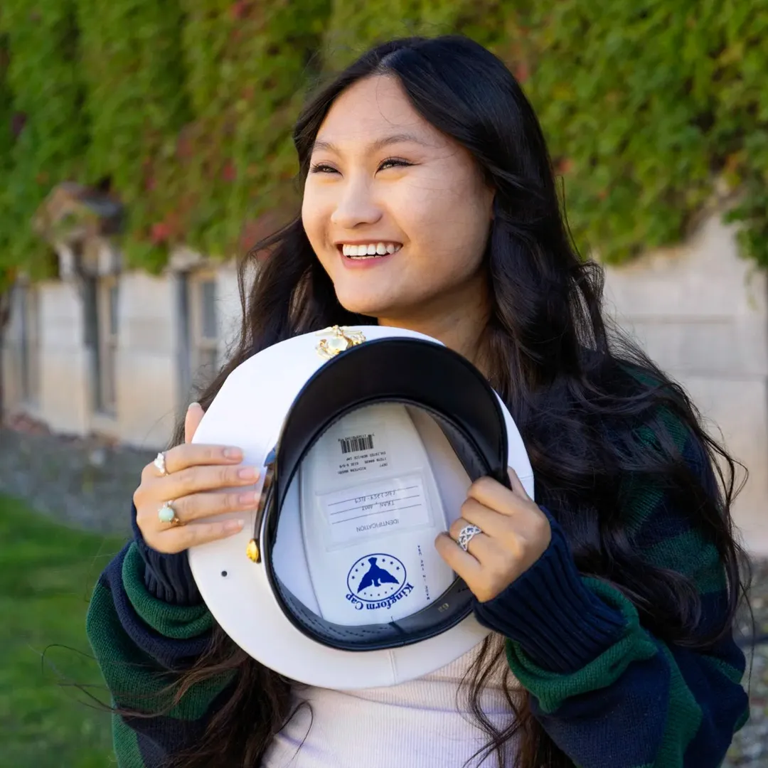 Amy Tran holds a military cap outside of Sims Hall.