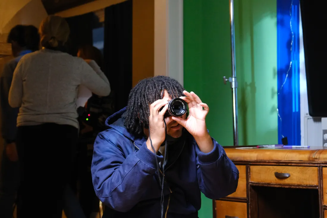 A person looks through a lens on a film set.