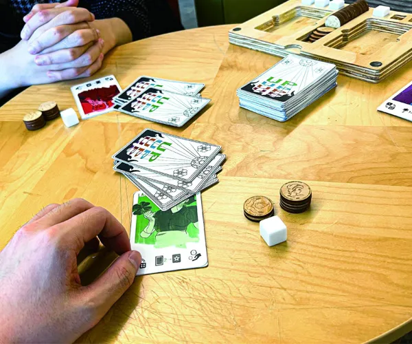 Two people at a table play UP.