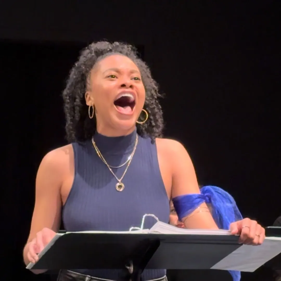 A person sings behind a music stand.