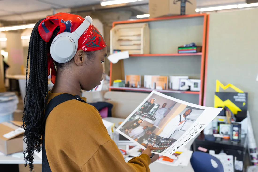 A student holds a printout of a design.