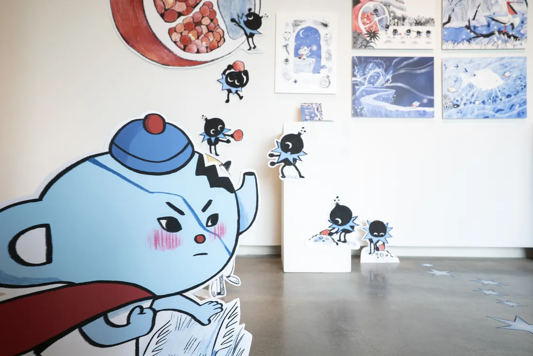 An exhibition of colorful illustrations of animals in a gallery.