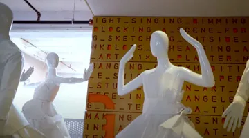 Mannequins wear white dresses.