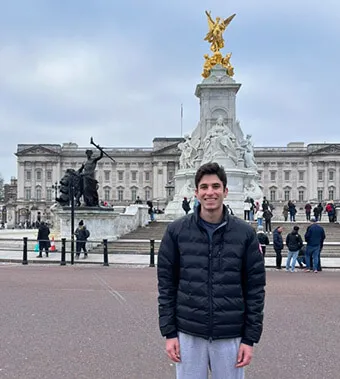 A student stands in front of an ornate building in London.