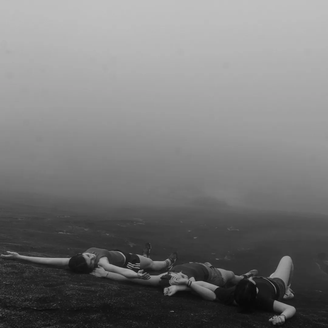 A gray photograph with three people on the ground.