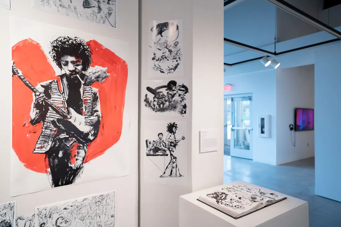 A gallery wall and pedestal showing illustrations of a musician with a guitar.