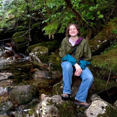 Katie Volz sits on rocks outside.