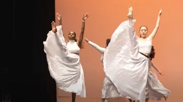 Dancers perform on stage.