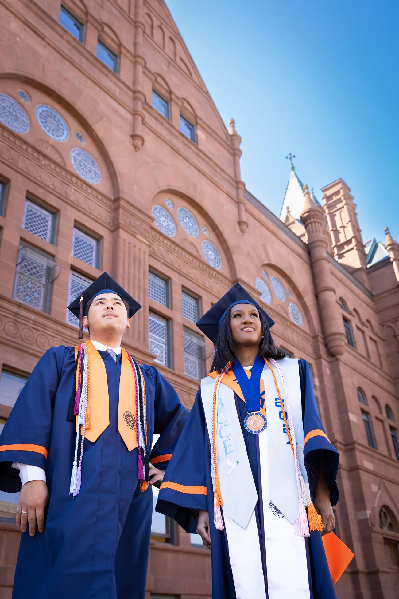 Two students in graduation caps and gowns.