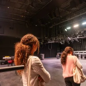 Two individuals in a theater space.