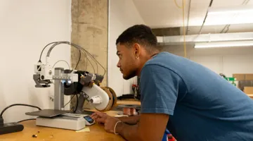 A student uses a 3D printer.