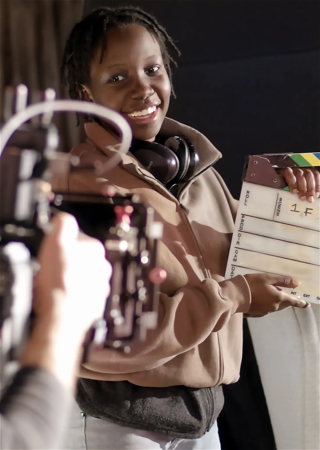 A student holds a film slate on a film set.
