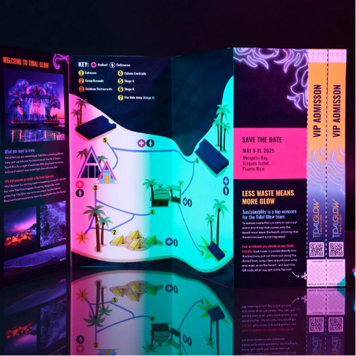 A vibrant neon-colored event brochure or festival guide displayed under dramatic lighting, featuring an illustrated island-style map, tropical graphics, event details, sustainability messaging, QR codes, and VIP admission tickets.