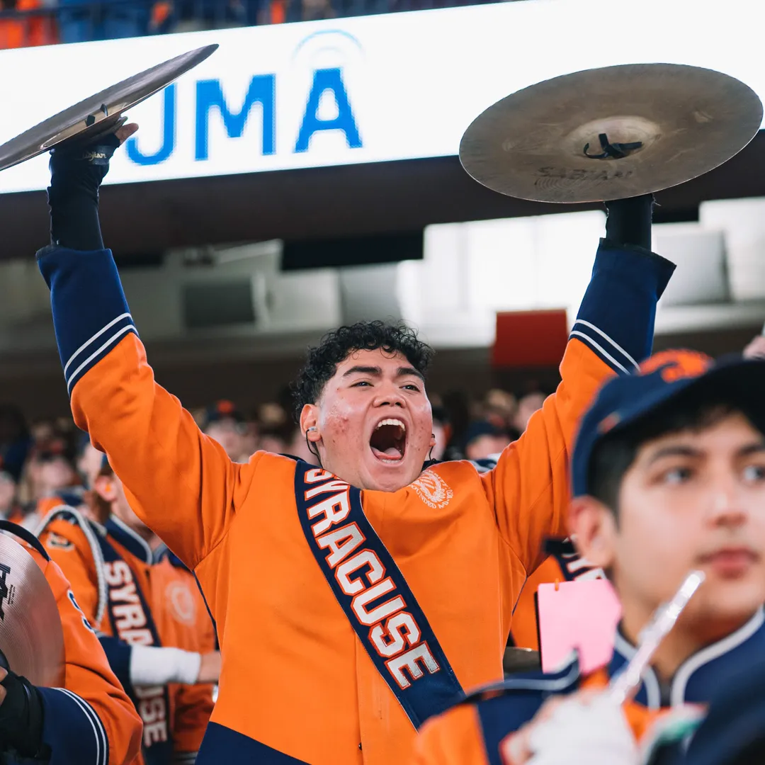 A person holds up cymbals.