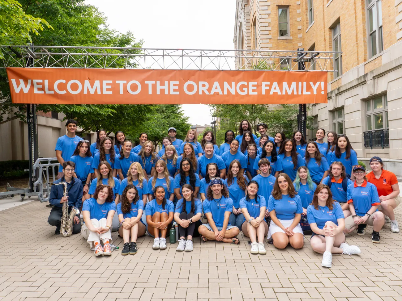 VPA Peer Advisors in front of a banner that reads “Welcome to the Orange Family.”