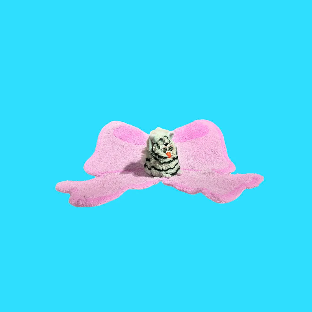 Furby on a pink carpet.