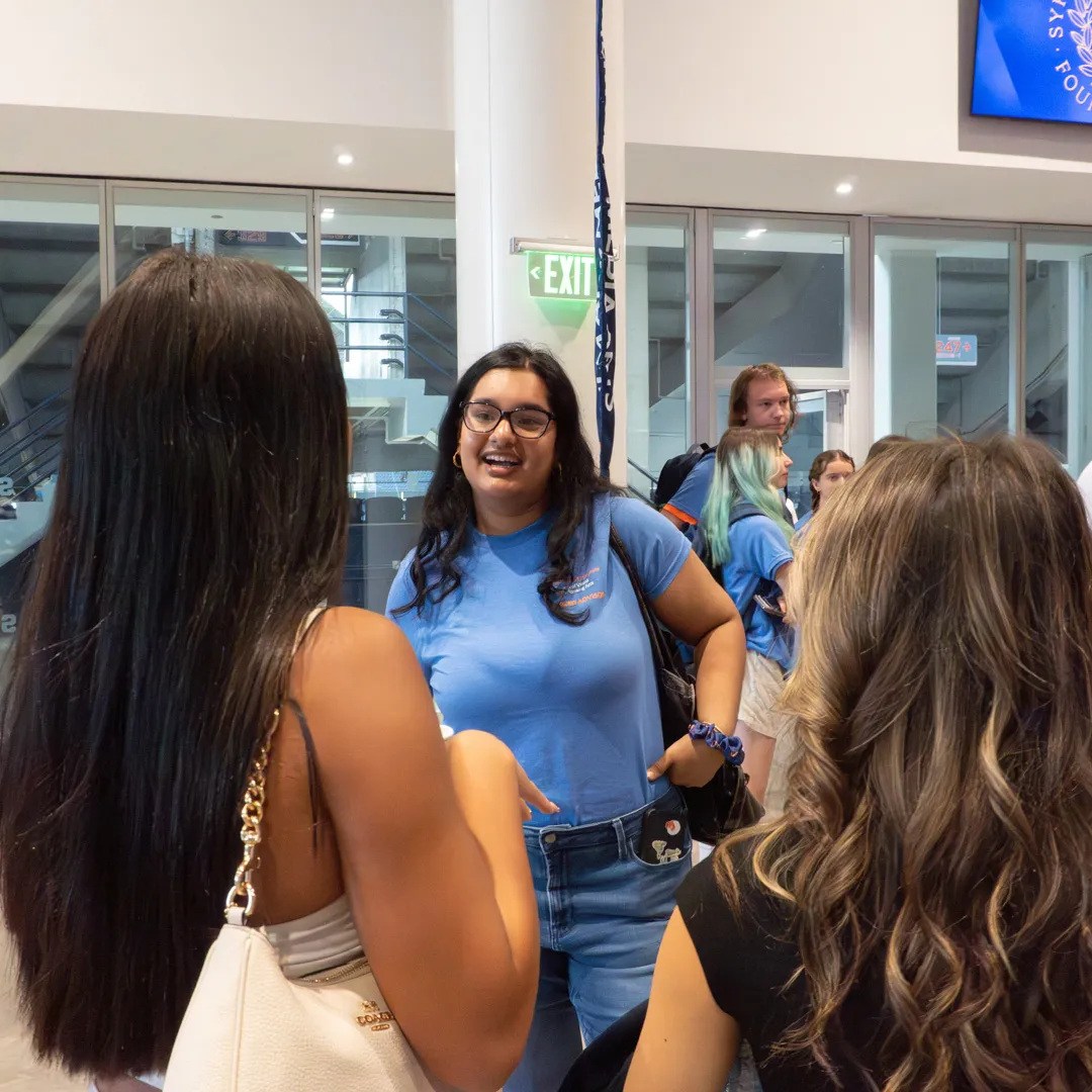 A peer advisor speaks to two individuals at the Dean’s Welcome.