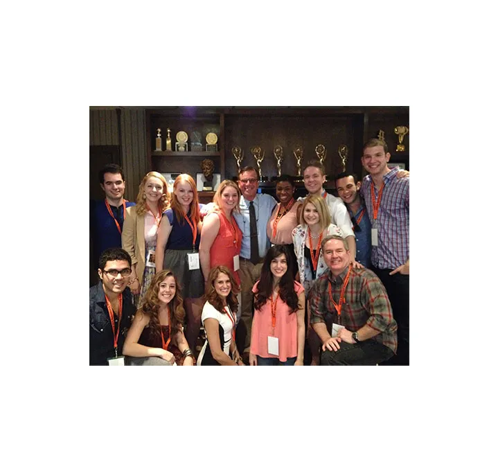 A group of students and Aaron Sorkin pose and smile.