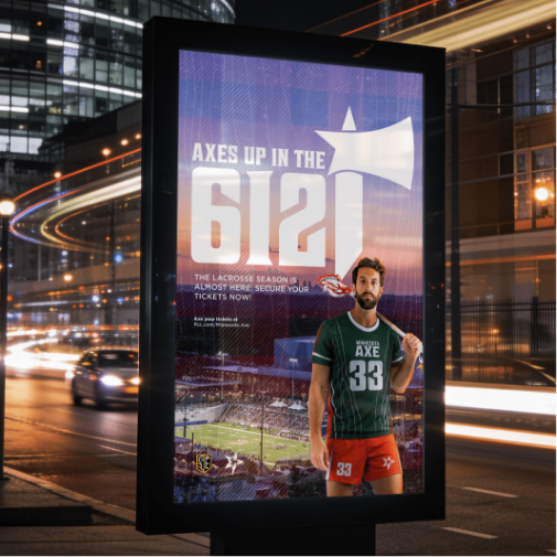A large illuminated billboard advertisement for a lacrosse team stands on a busy city street at night, featuring a player in a green “Minnesota Axe” uniform holding a lacrosse stick. Bold text reads “Axes Up in the 612,” while blurred car lights and modern buildings create a dynamic urban atmosphere.