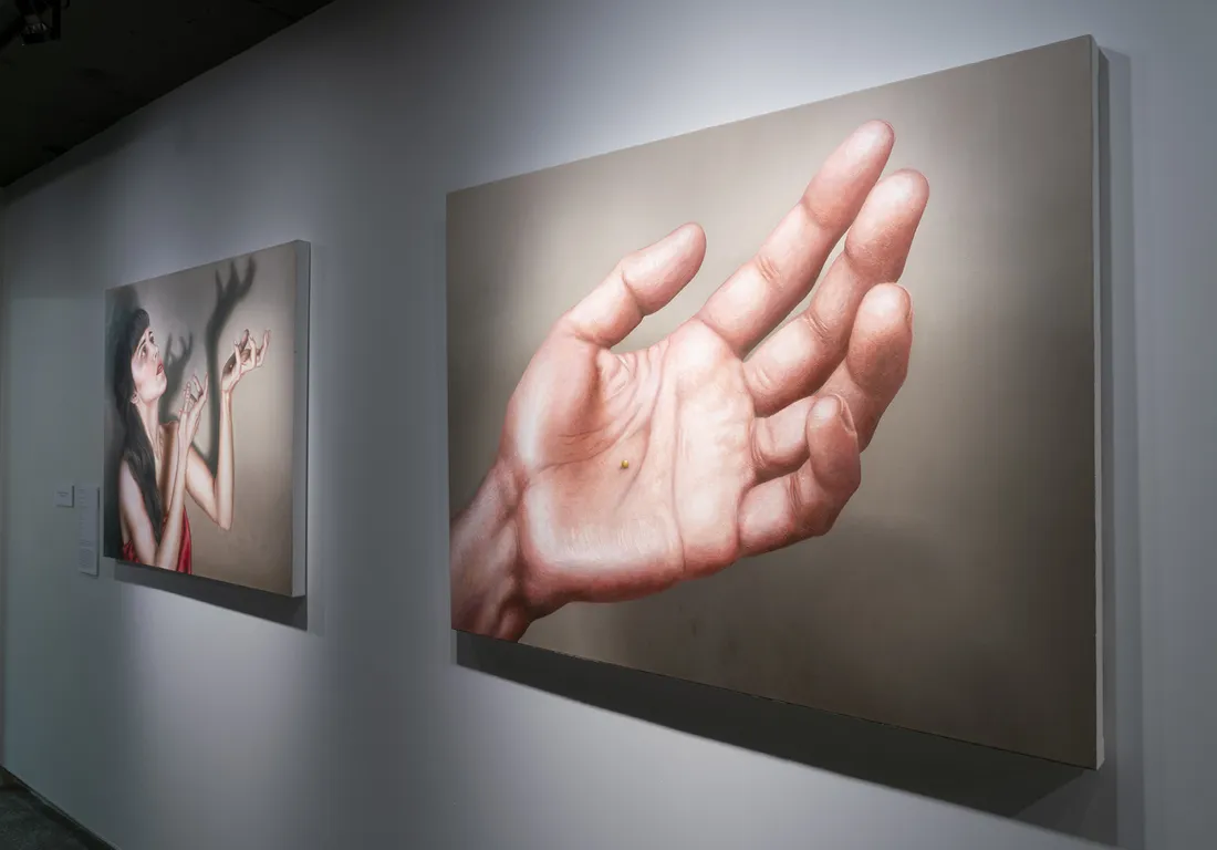 A painting of a hand on a gallery wall.