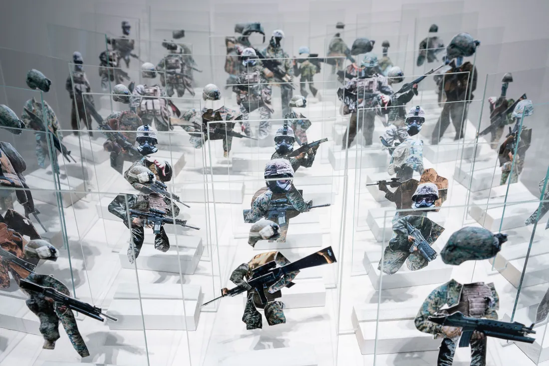 A group of small toy soldiers made from photographs and displayed in a gallery.