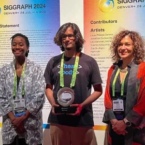 Three people standing and smiling while holding an award.