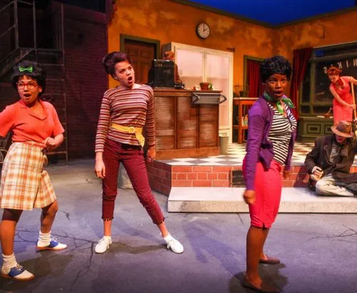 Three actors on stage in “Little Shop of Horrors.”