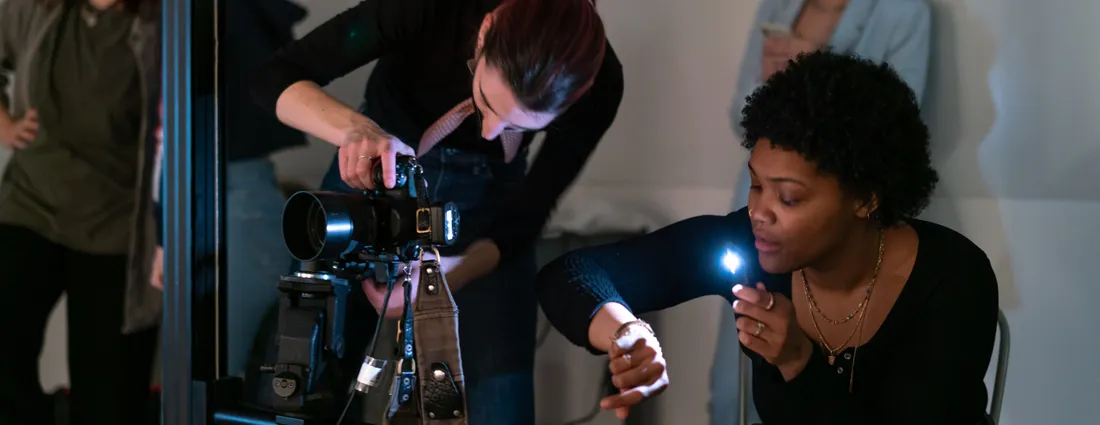 Two students work with a camera.
